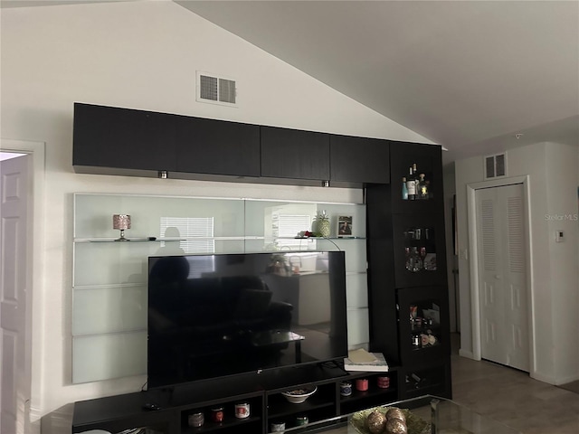 tiled living room featuring vaulted ceiling