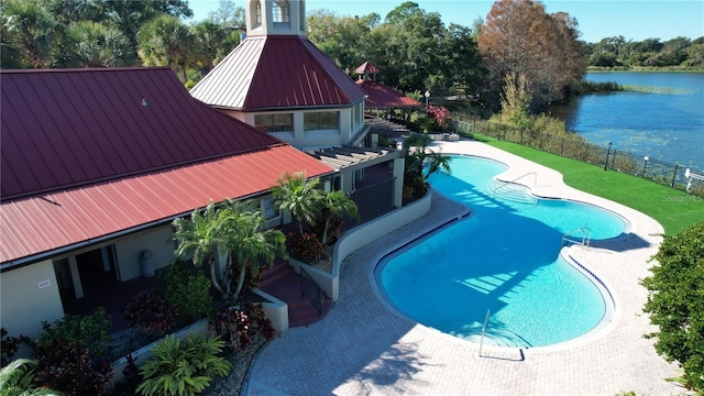 view of swimming pool featuring a water view and a patio