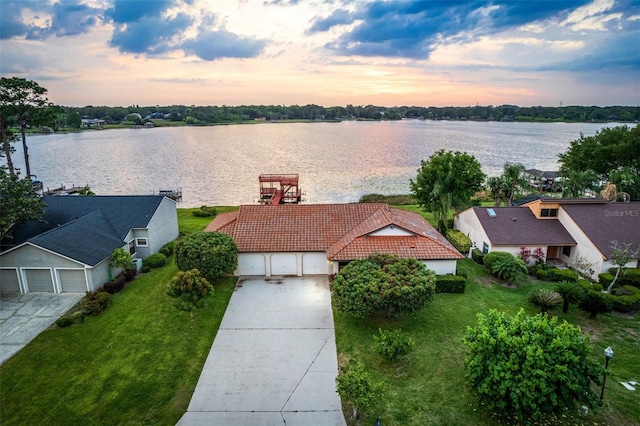 aerial view at dusk featuring a water view