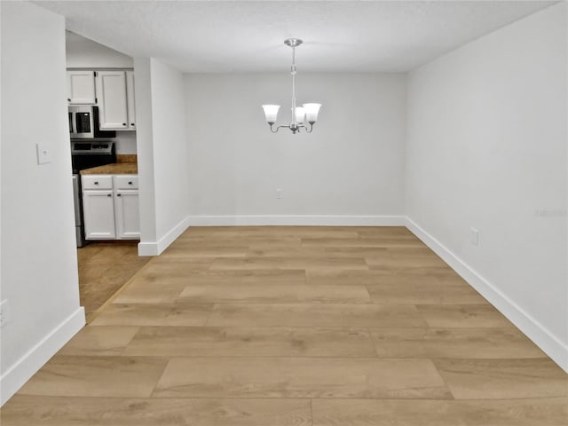 spare room featuring an inviting chandelier and light tile flooring