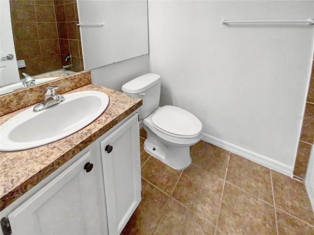 bathroom featuring tile flooring, toilet, and vanity with extensive cabinet space