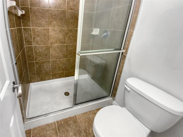 bathroom with walk in shower, tile flooring, and toilet