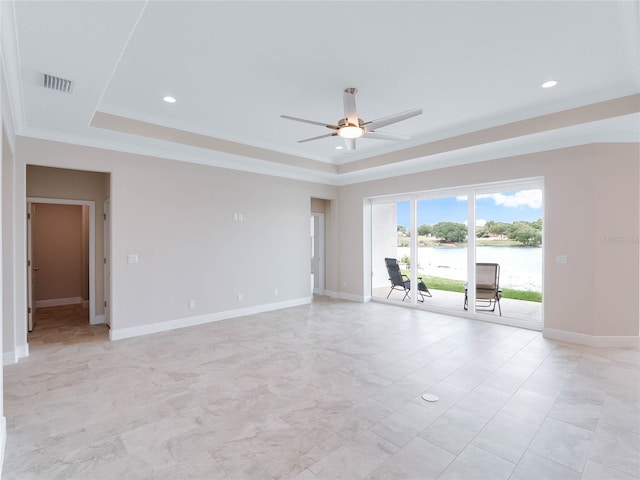 tiled empty room with a water view, a tray ceiling, and ceiling fan