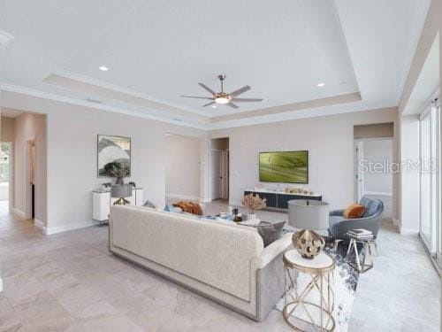 tiled living room with ceiling fan and a raised ceiling