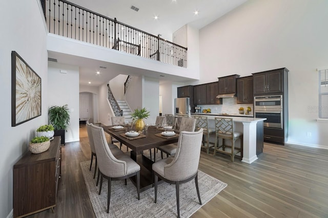 dining room featuring a high ceiling and dark hardwood / wood-style floors