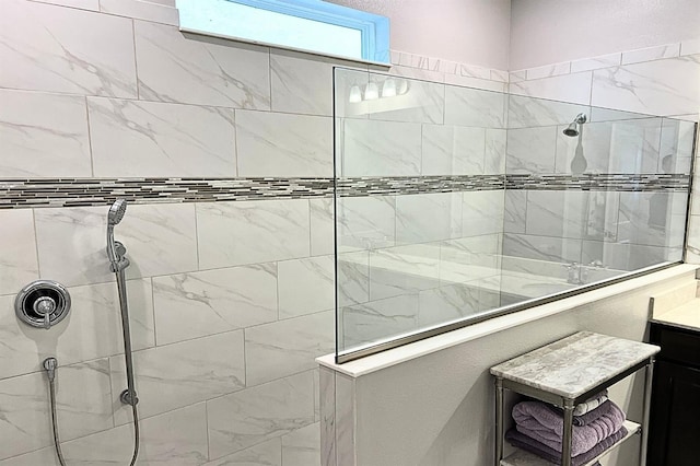 bathroom featuring a tile shower and vanity