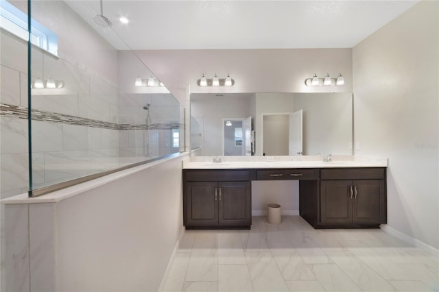 bathroom with a tile shower and vanity