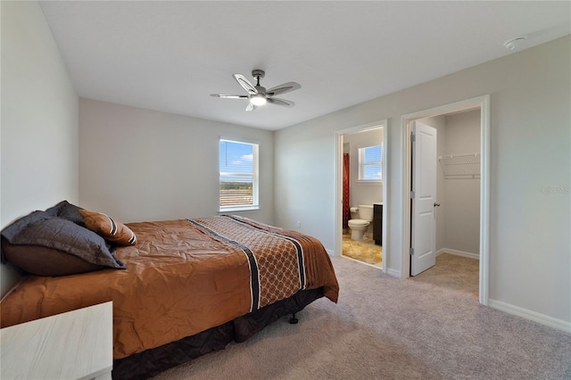 carpeted bedroom with ceiling fan, a closet, connected bathroom, and a spacious closet