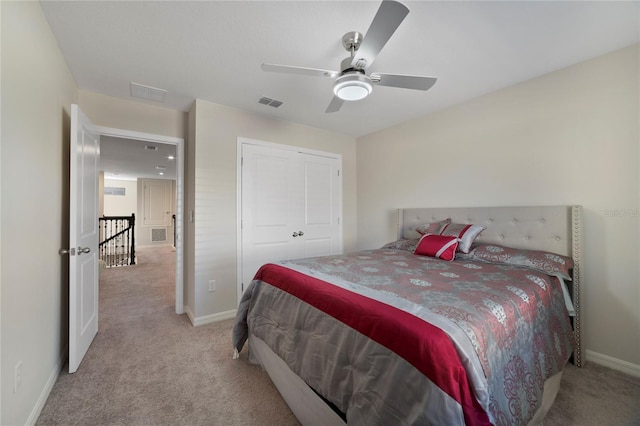 bedroom with light carpet, ceiling fan, and a closet