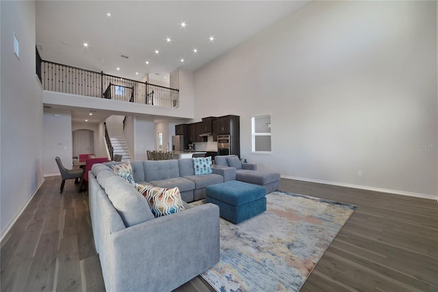 living room featuring a high ceiling and dark hardwood / wood-style floors