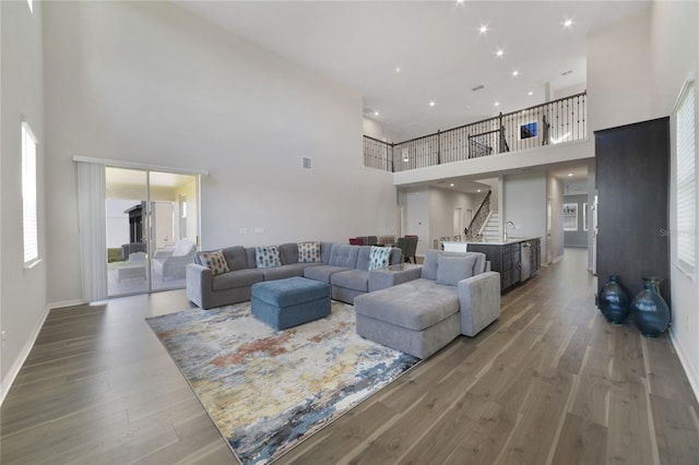 living room with sink, hardwood / wood-style floors, and a high ceiling