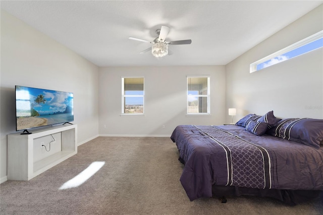 bedroom with ceiling fan, light colored carpet, and multiple windows