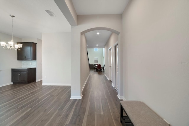 hallway featuring dark hardwood / wood-style flooring and a notable chandelier