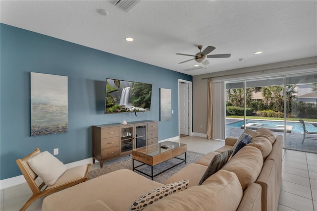 tiled living room featuring ceiling fan and a textured ceiling