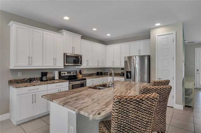 kitchen featuring a kitchen island with sink, white cabinets, sink, and stainless steel appliances