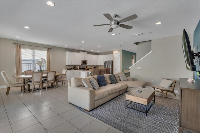 tiled living room featuring a textured ceiling and ceiling fan