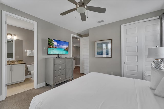 tiled bedroom featuring a closet, ceiling fan, and ensuite bathroom