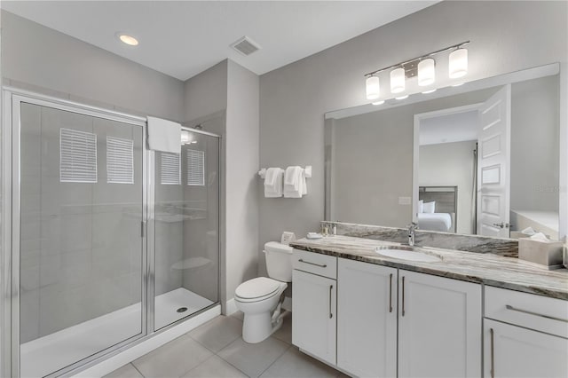 bathroom featuring vanity, tile flooring, a shower with shower door, and toilet