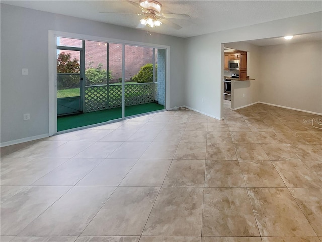 spare room featuring ceiling fan, a textured ceiling, and light tile flooring