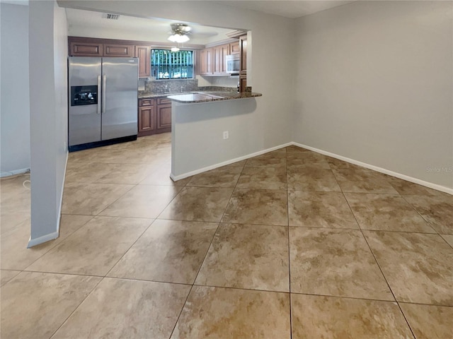 kitchen featuring backsplash, light tile flooring, and appliances with stainless steel finishes