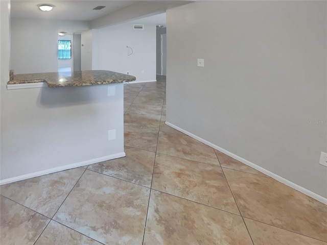 kitchen with light tile floors and dark stone countertops