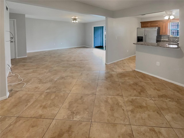 unfurnished living room featuring light tile floors and sink