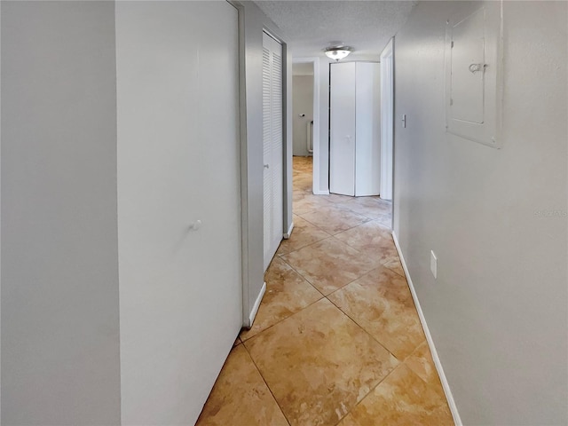 hall featuring light tile floors and a textured ceiling