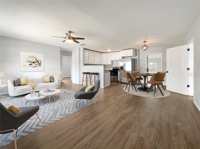 living room featuring ceiling fan and hardwood / wood-style flooring