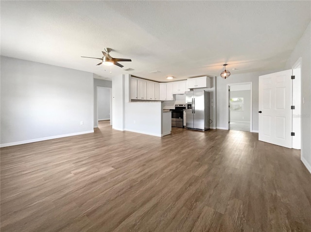 unfurnished living room with ceiling fan and dark wood-type flooring