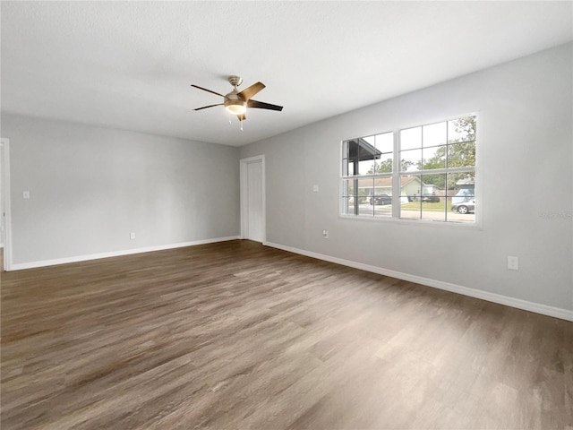 empty room featuring ceiling fan and dark wood-type flooring