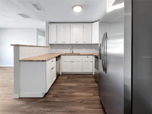 kitchen with white cabinetry, appliances with stainless steel finishes, sink, tasteful backsplash, and dark hardwood / wood-style flooring