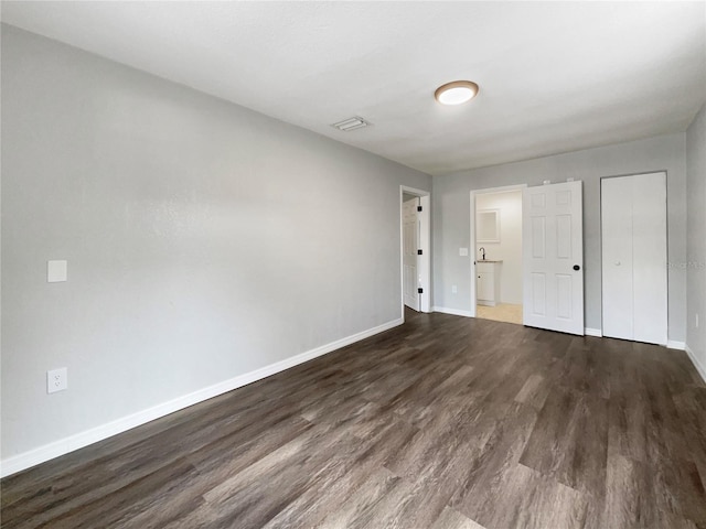 unfurnished bedroom featuring dark hardwood / wood-style flooring and a closet