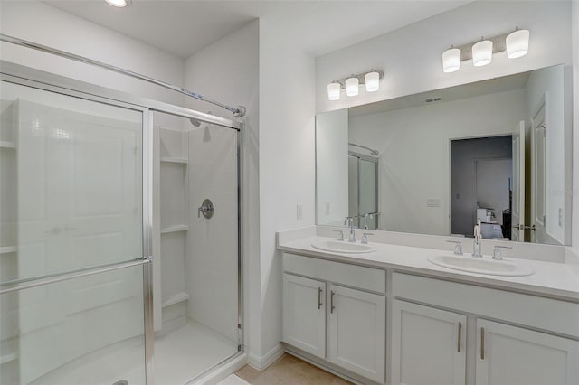 bathroom featuring a shower with shower door, tile floors, and double vanity