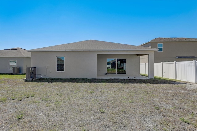 back of property featuring central AC unit, a patio area, and a yard