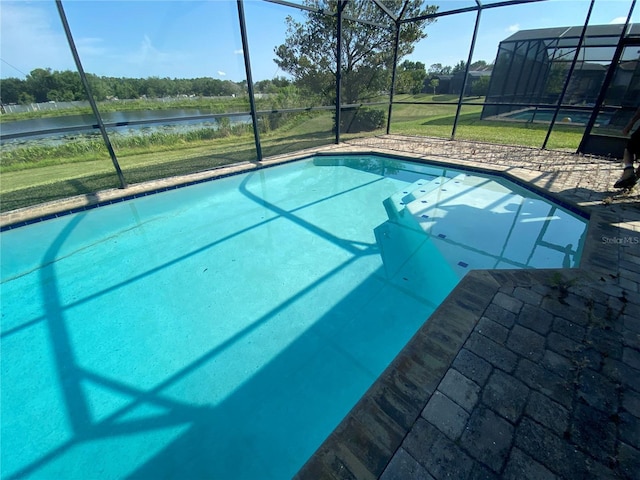 view of pool with a lawn and glass enclosure