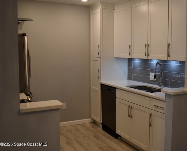 kitchen with tasteful backsplash, dishwasher, sink, and white cabinets