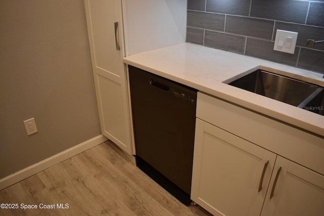 kitchen featuring dishwasher, sink, white cabinets, decorative backsplash, and light hardwood / wood-style flooring