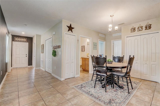 tiled dining room with a notable chandelier