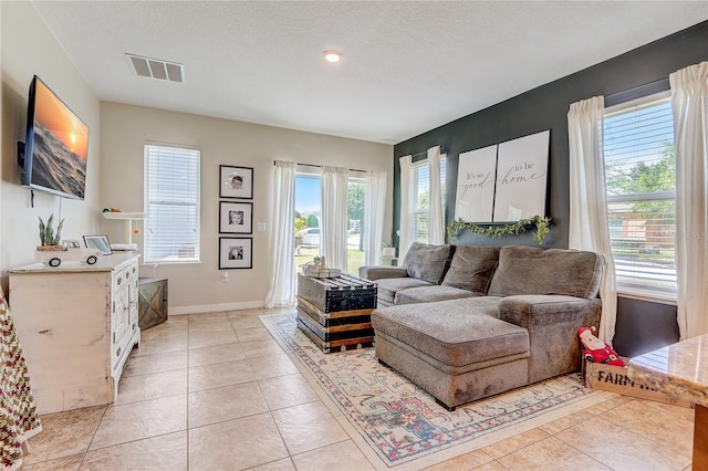 living room featuring light tile floors and a textured ceiling