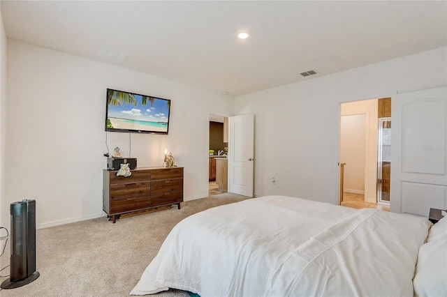 bedroom with light colored carpet and ensuite bathroom