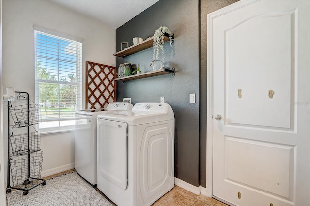 clothes washing area with separate washer and dryer and light tile floors