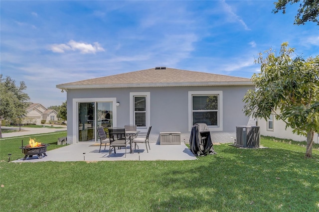 rear view of house featuring central AC unit, a fire pit, a patio area, and a lawn