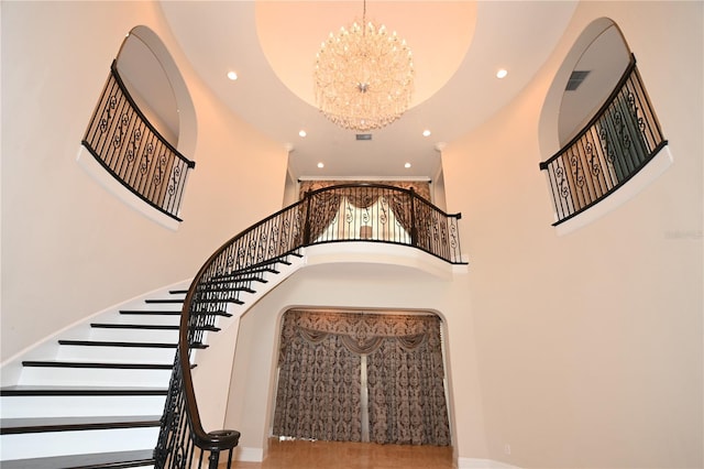 stairway featuring a chandelier and a high ceiling