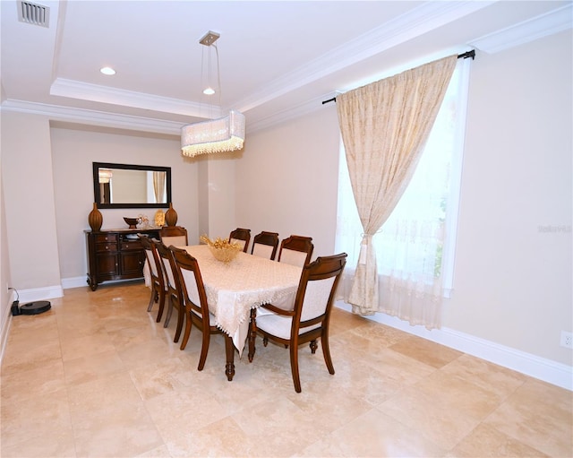 dining room featuring a raised ceiling and light tile floors