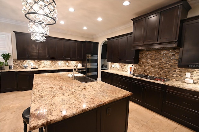 kitchen featuring tasteful backsplash, stainless steel double oven, black gas stovetop, and a kitchen island with sink