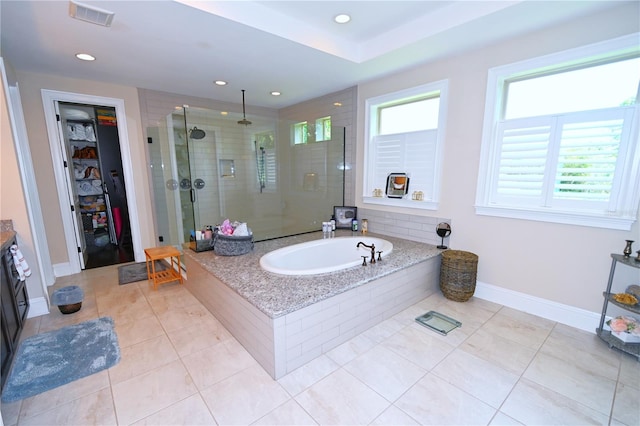 bathroom featuring tile flooring and shower with separate bathtub