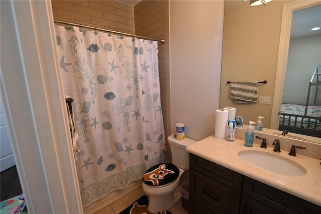 bathroom with tile flooring, toilet, and large vanity