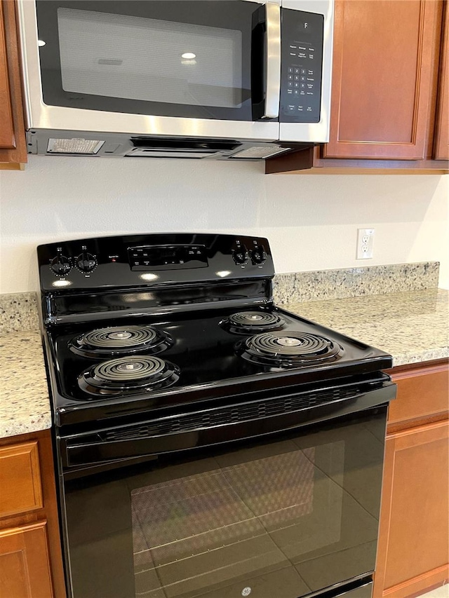 kitchen featuring black range with electric cooktop and light stone countertops