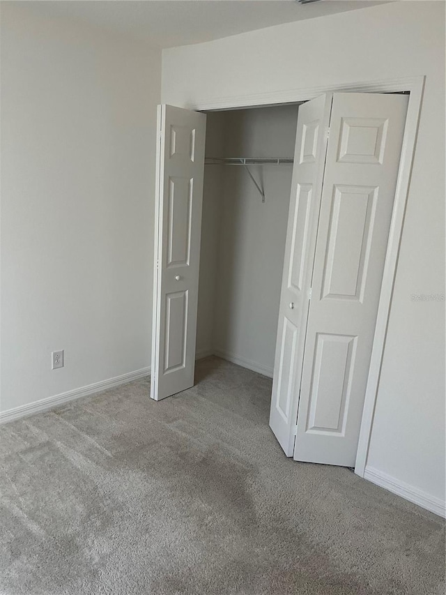 unfurnished bedroom featuring carpet and a closet