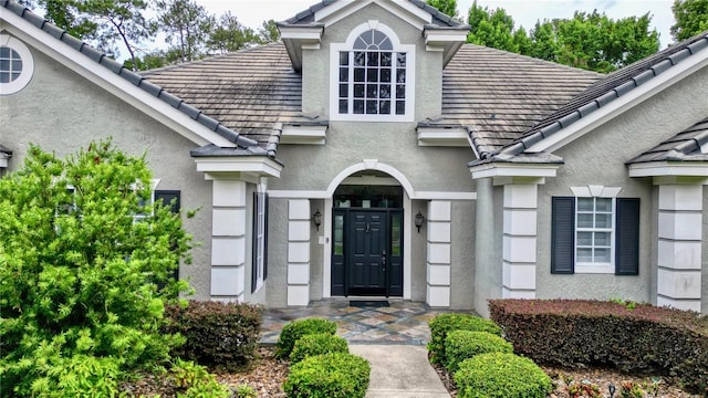 doorway to property with a tiled roof and stucco siding